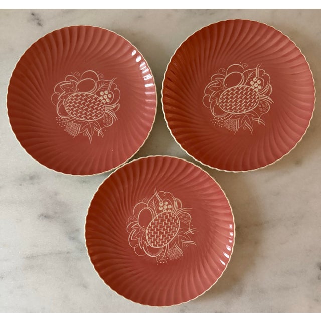 Set of 3 scalloped edged lunch plates in a dusty rose/salmon color with a festive leaf and fruit design on the center....