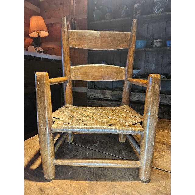This antique child’s ladder-back chair, dating from the mid-19th to early 20th century, showcases a classic Shaker-...