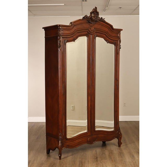 High Quality Antique French Louis XV Style Armoire Crafted In Rich Mahogany With Elaborate Rococo Inspired Carved Crest,...