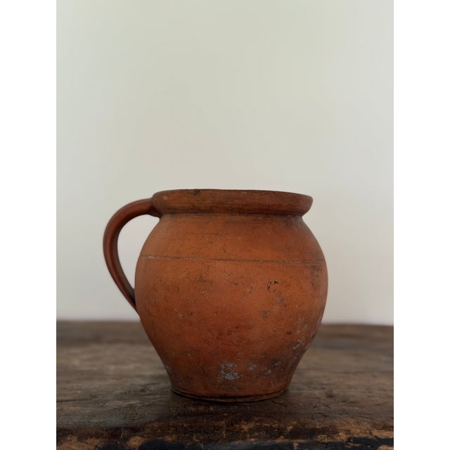 An antique French terracotta jug from the 19th century, wheel-thrown in red earthenware with an applied loop handle. The...