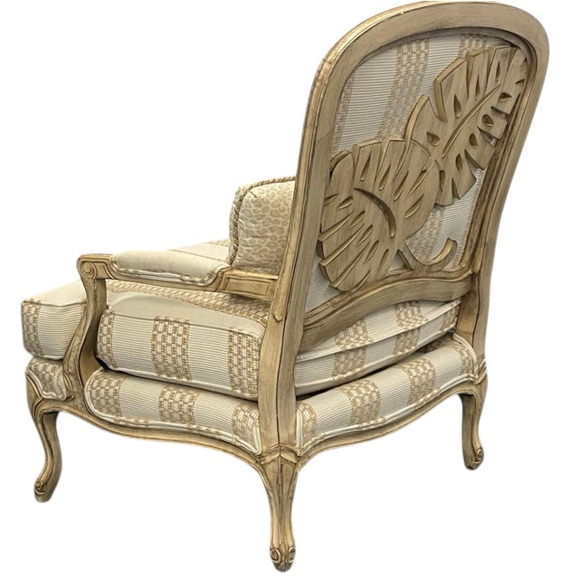 Elegant and timeless Bergère armchair by Taylor King, featuring a beautifully carved wood back that adds sculptural...