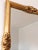 A giltwood beveled mirror with golden rose accents, inspired by Rococo style and made in Italy around 1960. Object: Mirror...