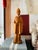 A beautifully hand-carved wooden figure depicting a robed scholar or elder, rendered with a calm expression and graceful...