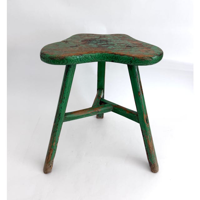 This rustic elm handcrafted stool has remnants of green paint and age earned patina. Three-legged with mortar and tenon...