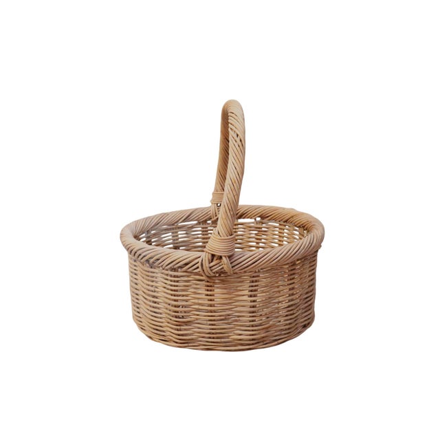 A classic French style wicker shopping basket. Made of woven rattan, with a rope twisted handle secured to the rope...