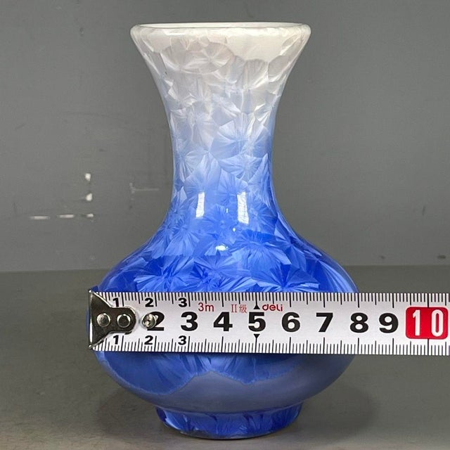 A striking Chinese porcelain vase featuring a vibrant blue crystalline glaze. The vase has a classic pear shape with a...