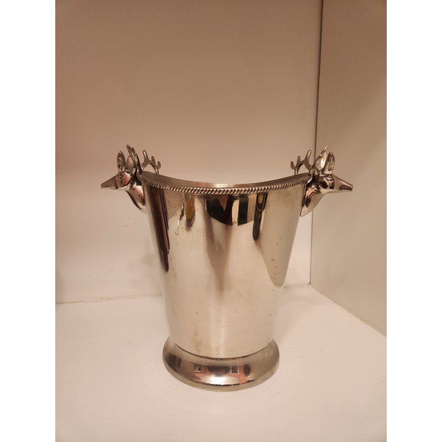 A polished silver champagne bucket crowned with finely detailed stag heads—classic, masculine, and winter-ready. Whether...
