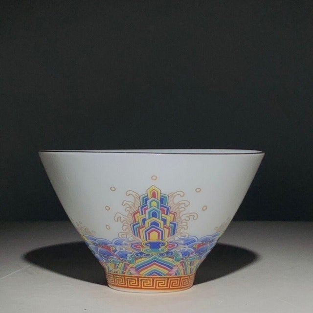 A charming Chinese porcelain tea cup. The exterior is finely hand-painted in vibrant Famille Rose enamels with a "Hai Shui...