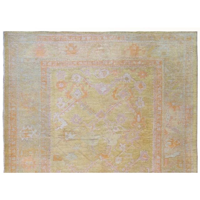 A stunning early 20th century Turkish Oushak rug with a beautiful large-scale stylized trellis floral pattern with pink,...