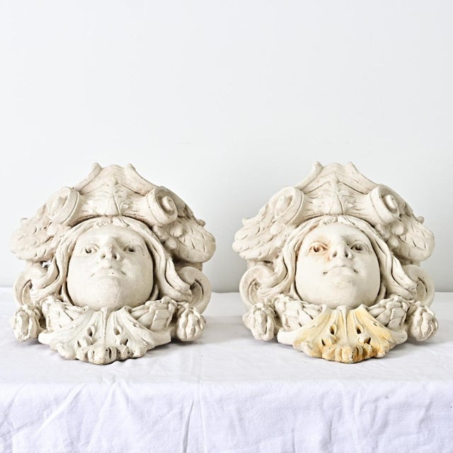 A pair of French, 20th century wall-mounted plaster planters of stylized Medusa figures, not with an abundance of snakes...