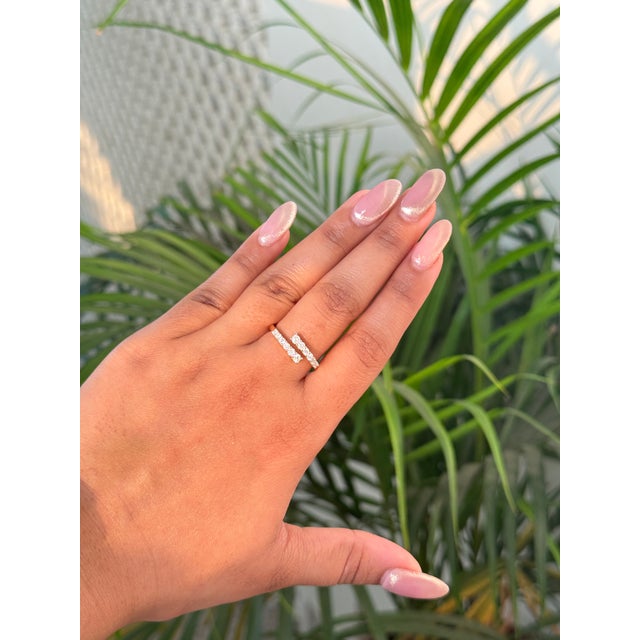 This modern diamond open-bypass ring is crafted in 14K yellow gold and features a sleek, minimalist silhouette accented...