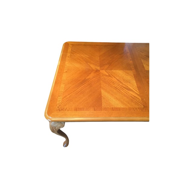 Large rectangular dining table in a classic Chippendale style. Bookmatched veneered top with rectangular banded trim. Four...