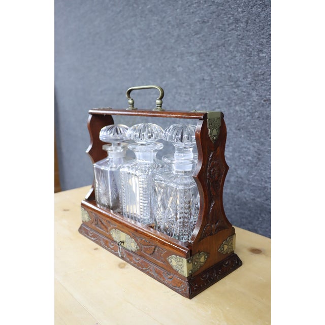 19th Century Carved Oak Tantalus with brass accents.