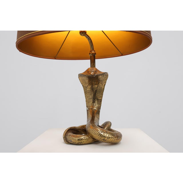 Striking and highly decorative Hollywood Regency table lamp from France, dating to the 1970s. The lamp features an...