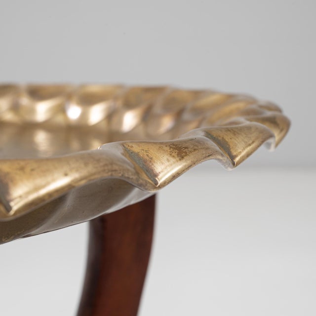 This 1970s Moroccan Mid-Century coffee table combines sculptural form with artisanal detail. The solid walnut base...