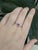 Delicate and refined, this 14k gold ring showcases a 0.99ct oval-cut purple sapphire from Ceylon, measuring 6x4mm. The...