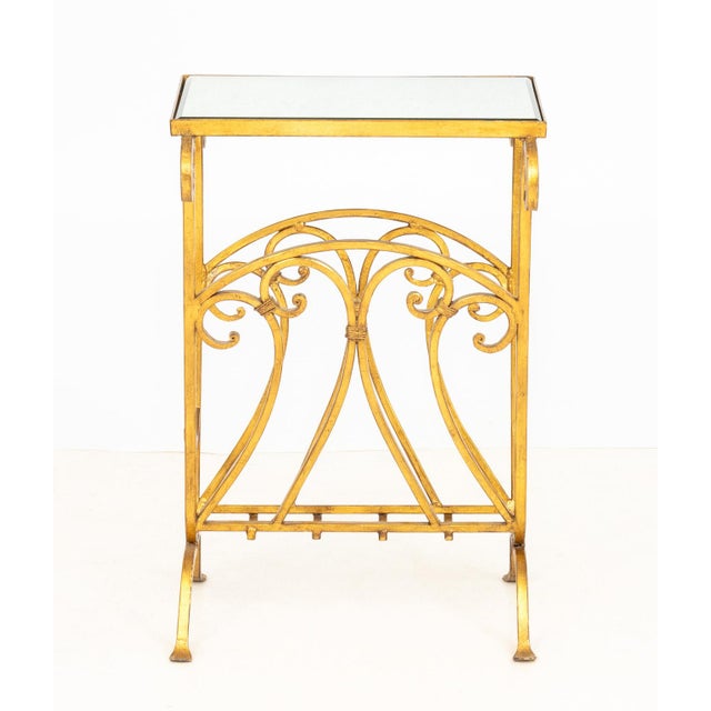 Hollywood Regency Mirrored Gilt Brass Side Table, the beveled glass top above magazine rack base. 24" H x 16" W x 15.5" D....