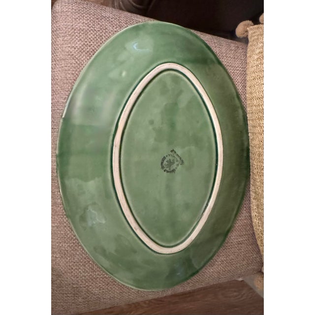 A beautifully crafted green ceramic serving platter by Bordallo Pinheiro of Portugal, measuring 15.25″ × 11.25″. This...