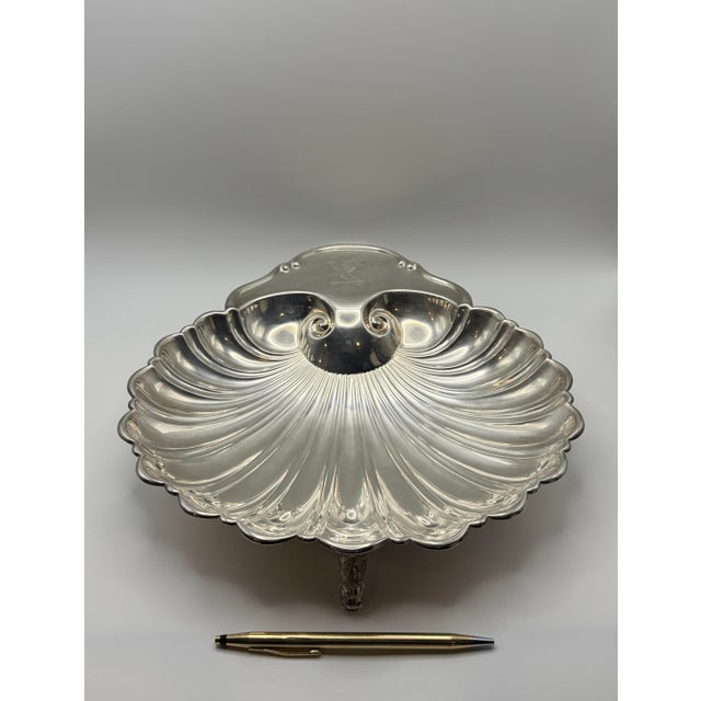 A beautifully sculpted vintage silver-plated serving tray featuring three charming fish-form feet and elegant radiating...