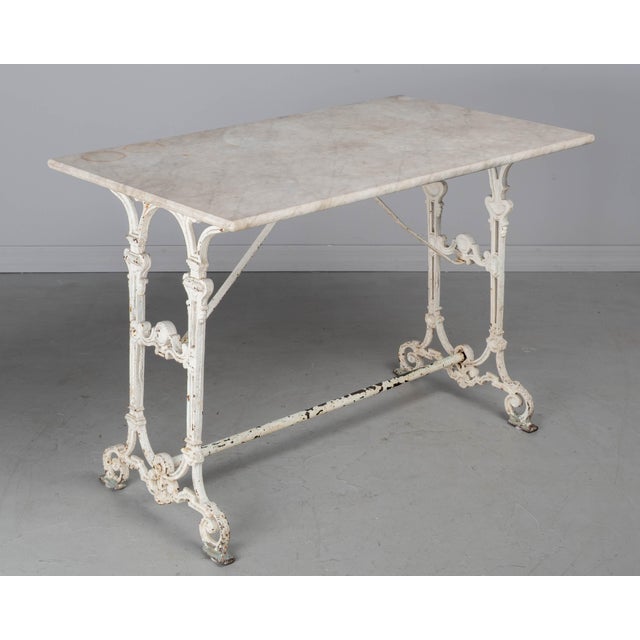 A 19th century French cast iron, marble top bistro table, or garden table, with white painted patina. Good quality, heavy...