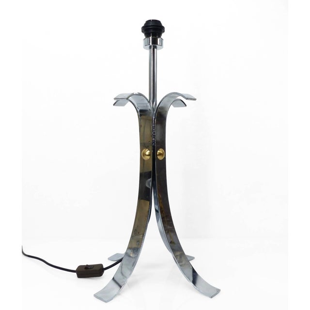 Large, four-legged lamp base in chromed steel, characterized by a sculptural structure with four curved arms. The design...