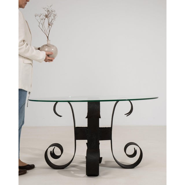 This side table makes its impression through glass top, black wrought iron H-form base. The piece dates to 20th Century,...