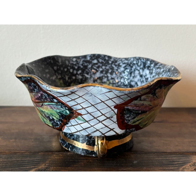 Glossy black hand-panted Italian bowl with scroll details surrounding the pedestal base. Painted with trellis, leaf, and...