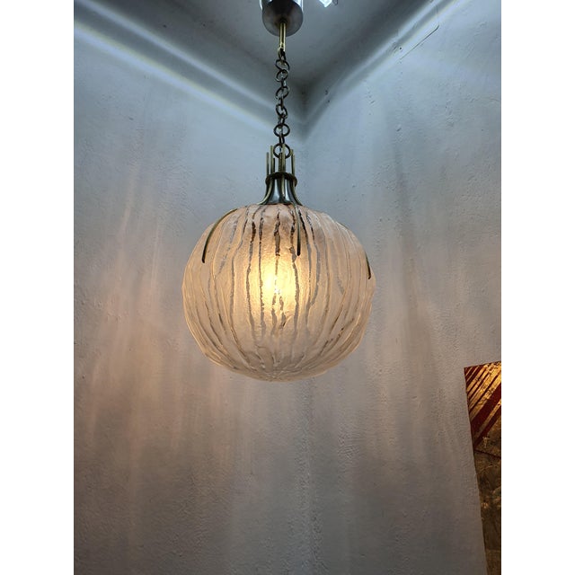 Mid-century chandelier pendant. Frosted and textured glass sphere and Brass Ornaments. by Italian lighting designer and...