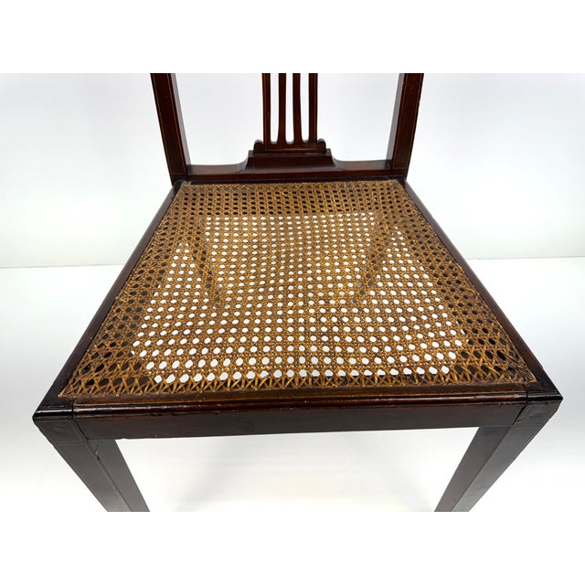 This elegant, vintage chair offers classic craftsmanship with its intricately designed backrest and finely woven cane...