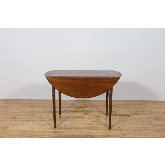 This stylish gate-leg (drop-leaf) dining table was manufactured in the United Kingdom during the 1960s. It is an excellent...