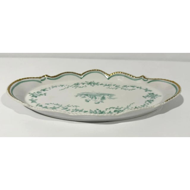 Sweet little dresser tray featuring a putto in a garden. Green decoration with gold trim