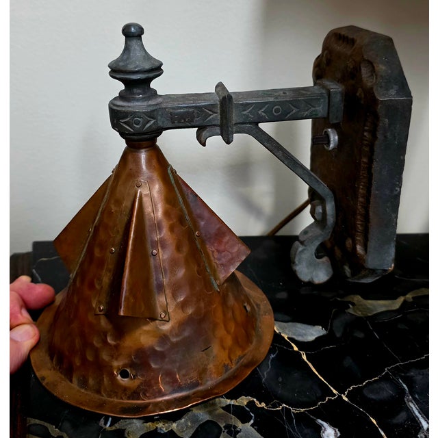 This Arts and Crafts Hammered Copper Wall Sconce features a black metal arm with a corded cone shade, adding a touch of...