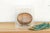 This hand-coiled terra cotta bowl is a visceral example of early ceramic artistry, characterized by its deep ochre and...