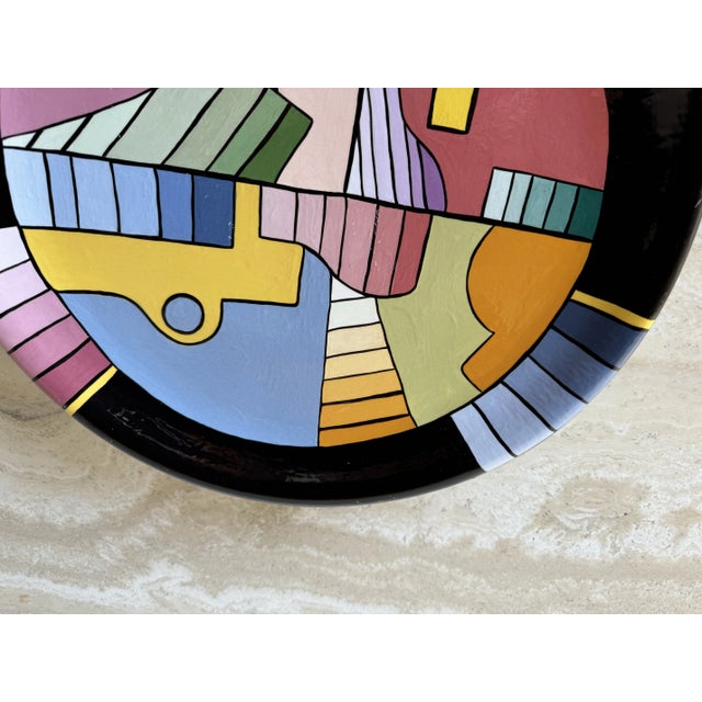 This vibrant ceramic wall plate from the 1980s showcases a bold postmodern geometric abstract design. Hand-painted with a...