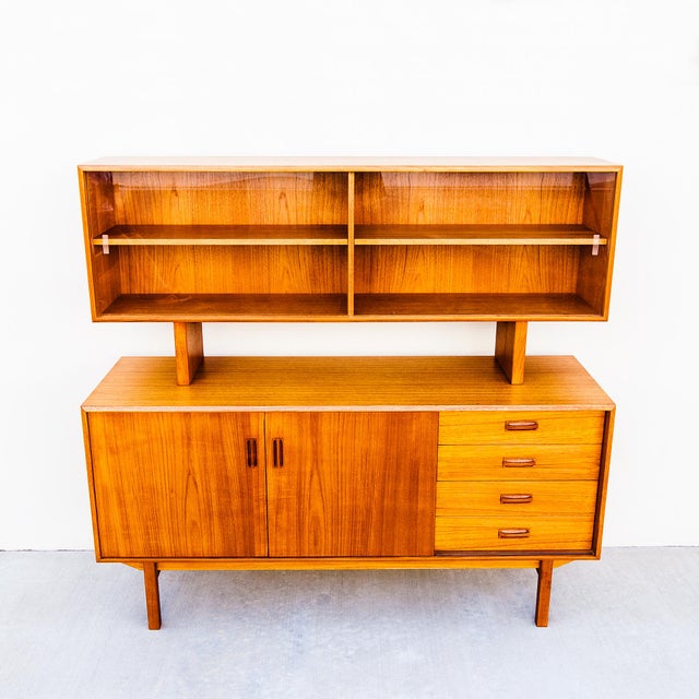 Vintage Danish Modern teak sideboard with vitrine from the 1970s. The case rests atop a clean, architectural base, with...