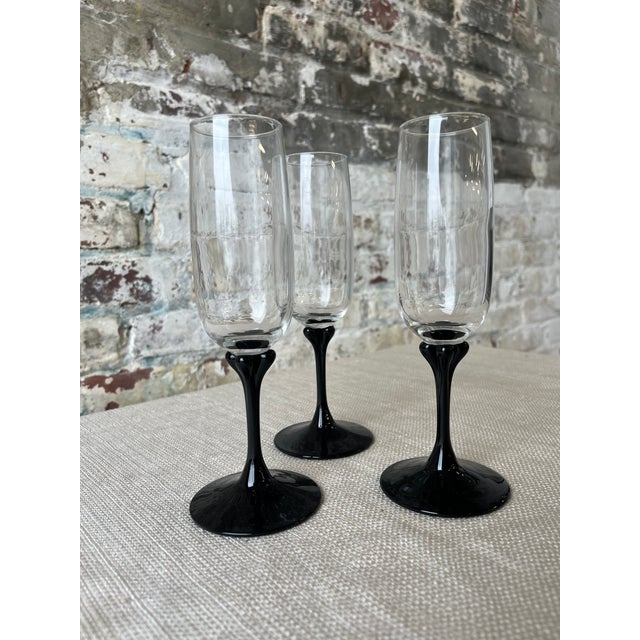 Raise a glass to timeless style. This trio of vintage champagne flutes features sleek black stems and crystal-clear...