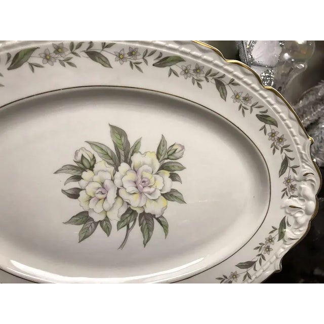 Delicate magnolia floral center in soft hues of pink and yellow, surrounded by a floral trim with a scalloped and embossed...