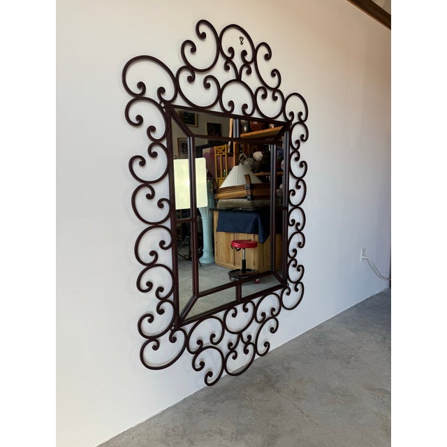 This stunning vintage Hollywood Regency–style wall mirror features an elaborate iron frame with dramatic scrolling details...