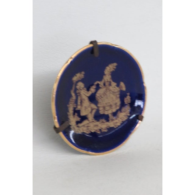 his lovely miniature plate is made of Porcelain and comes with a metal stand. This dainty porcelain collectible features a...