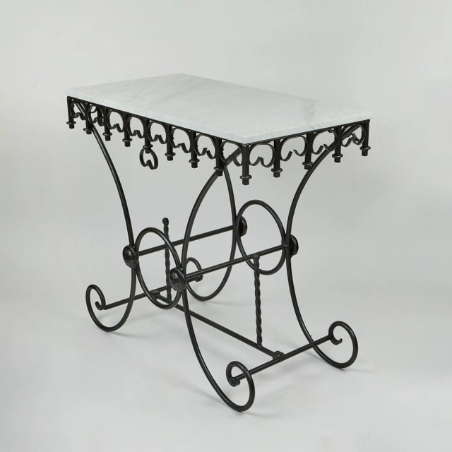 Charming, decorative and functional, this vintage French pastry table has a newly oil rubbed iron base with a rich bronze...
