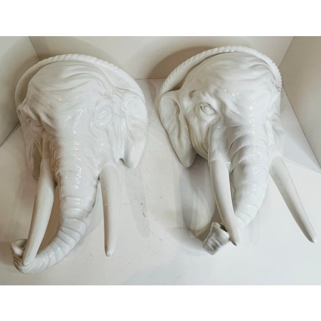 Striking pair of Italian ceramic elephant wall brackets featuring sculptural elephant heads with long tusks and curled...