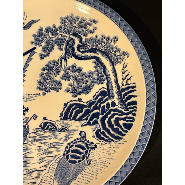 This vintage Japanese blue and white porcelain charger plate features a Takarabune (treasure ship) and Minogame (long-...