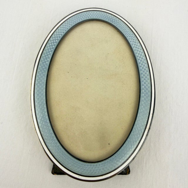 This is a beautiful early 20th‑century guilloché enamel picture frame crafted in silver with a gold‑washed (vermeil)...
