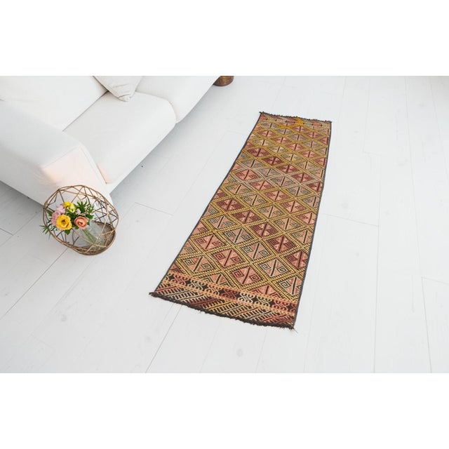 This is a vintage Turkish Oushak rug from the Mid 20th Century. The piece was hand-knotted.