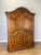 An elegant Vintage French oak wardrobe with two large panelled doors, a sweeping curved top and decorative detailing that...