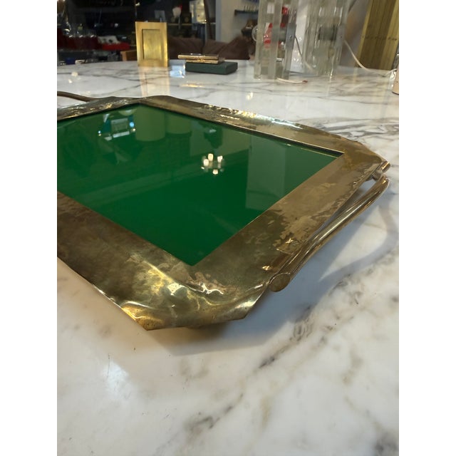 Striking vintage tray featuring a sculptural, hand-formed brass frame paired with a rich green glass inset. The organic,...