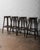 This set of four vintage wooden bar stools exudes rustic charm with their weathered dark finish and sturdy, classic...