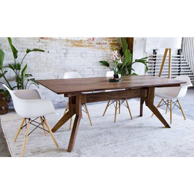 A gorgeous handcrafted dining table in solid American black walnut, made by Moderncre8ve in Ohio. The sculptural splayed-...