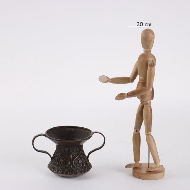 Embossed copper vase finely worked with a burin. The two handles have an engraved decoration with repeated motifs. This...