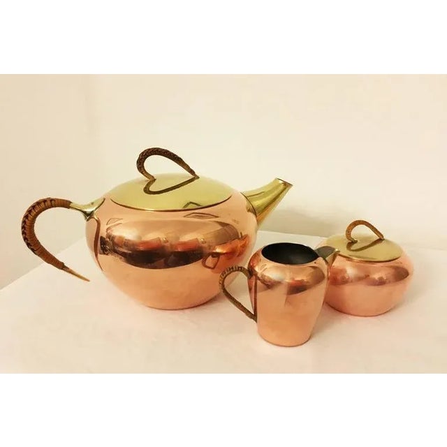 Copper or brass set consisting of a tea pot, a milk creamer, and a sugar bowl designed by erich kolbenheyer for ekw...